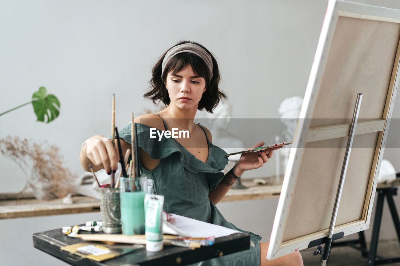 Young Woman Painting On Canvas While Id 134532678