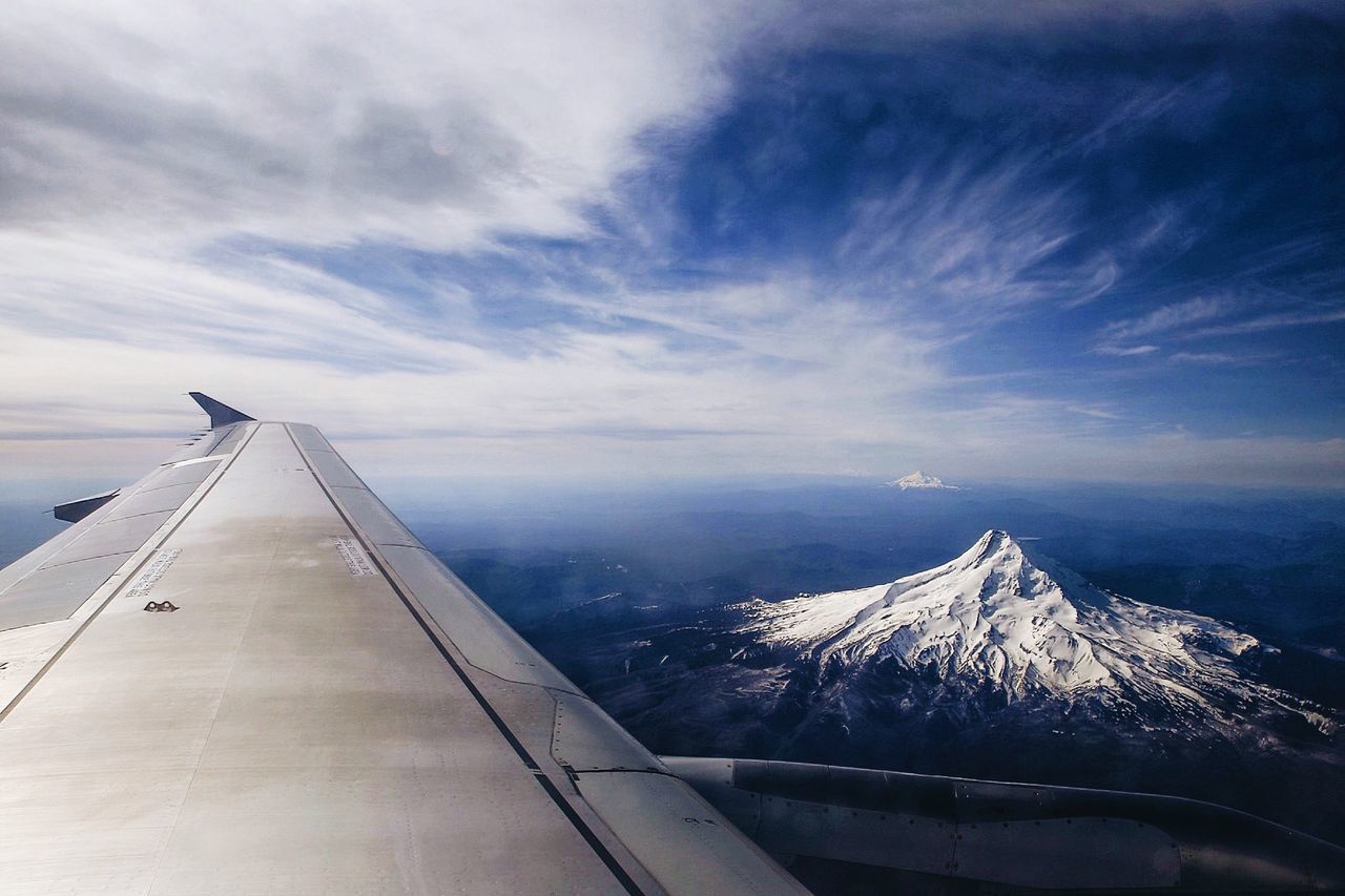 Aircraft wing with snowcapped mountain on background