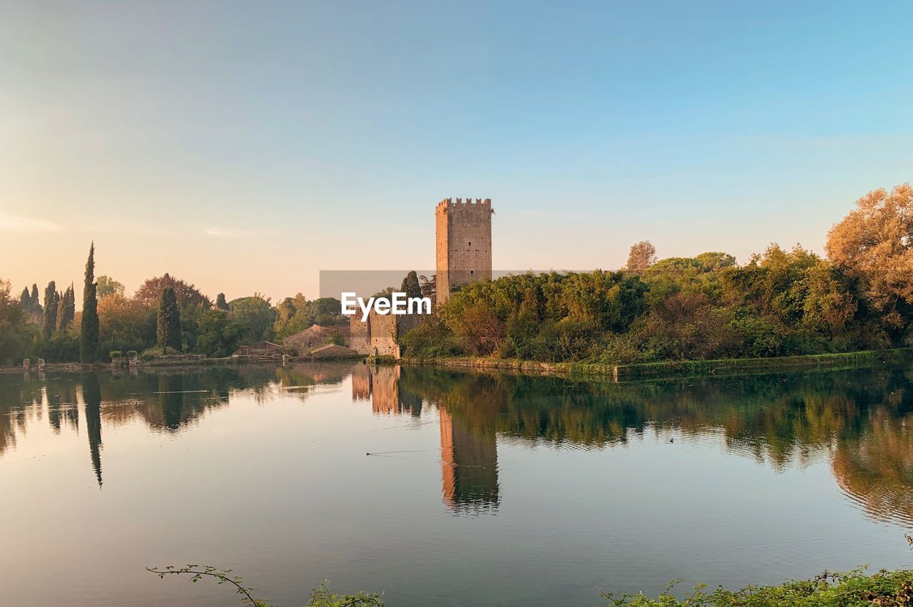 Scenic view of lake by buildings against sky