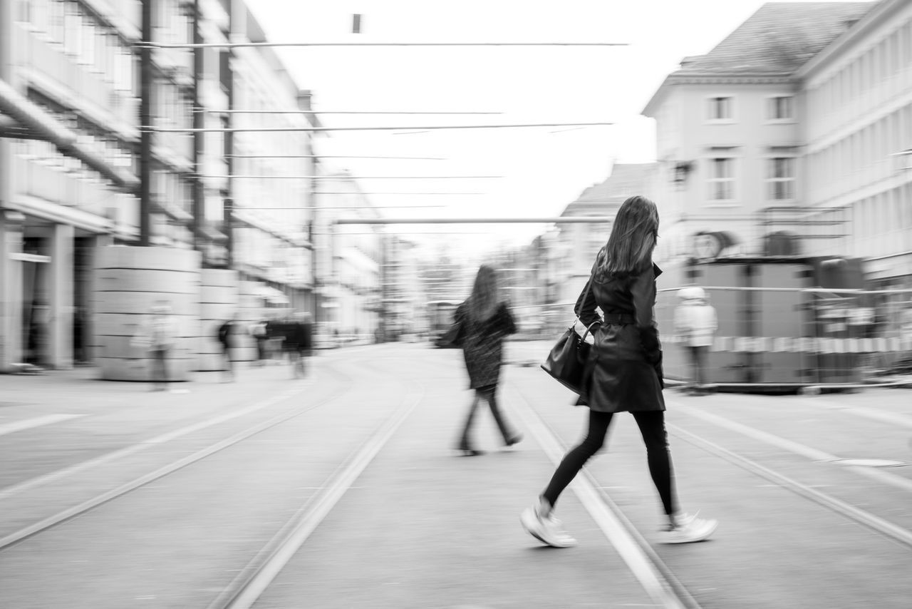 WOMAN STANDING ON CITY STREET