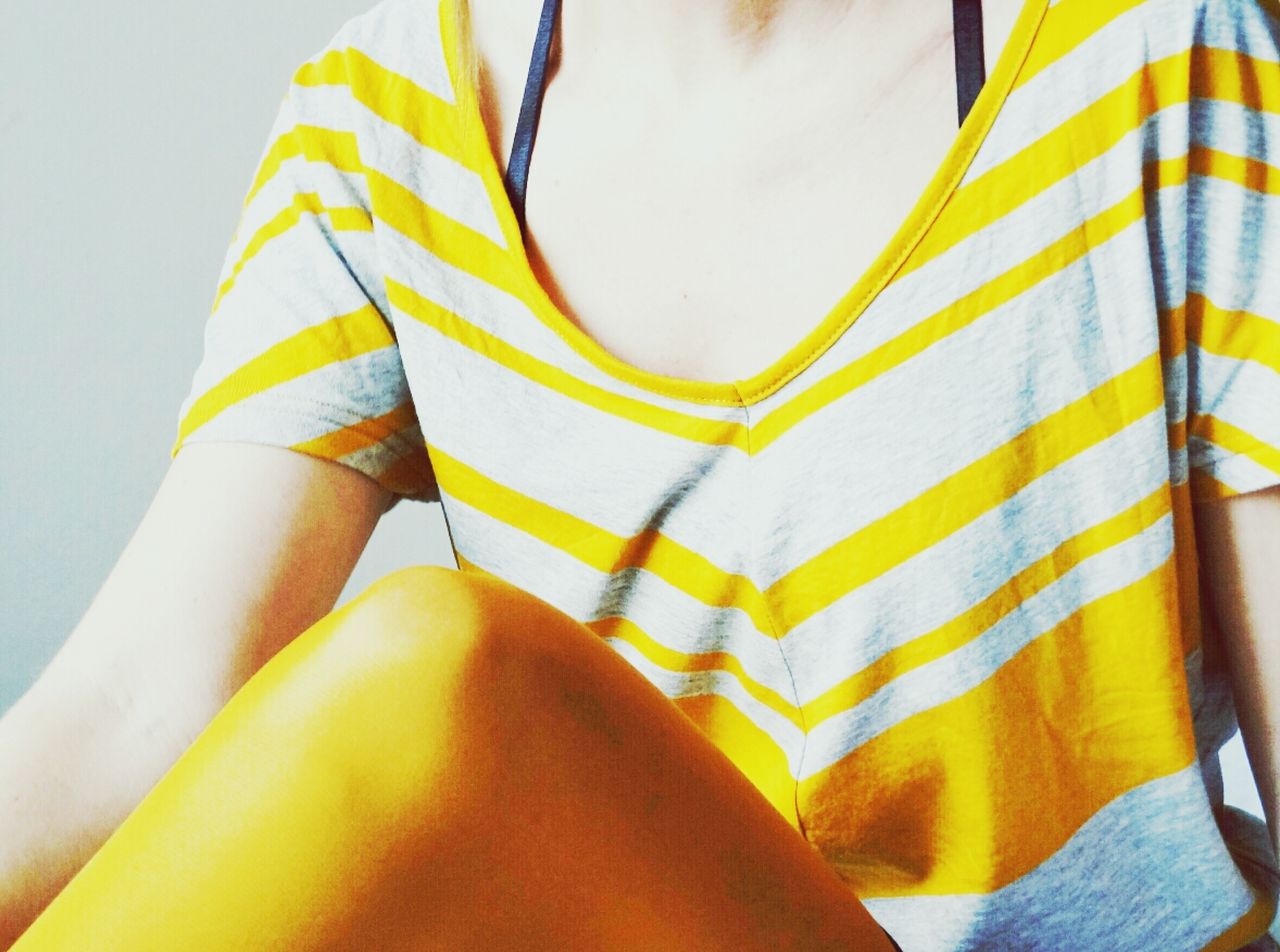 Mid section of woman sitting in striped top