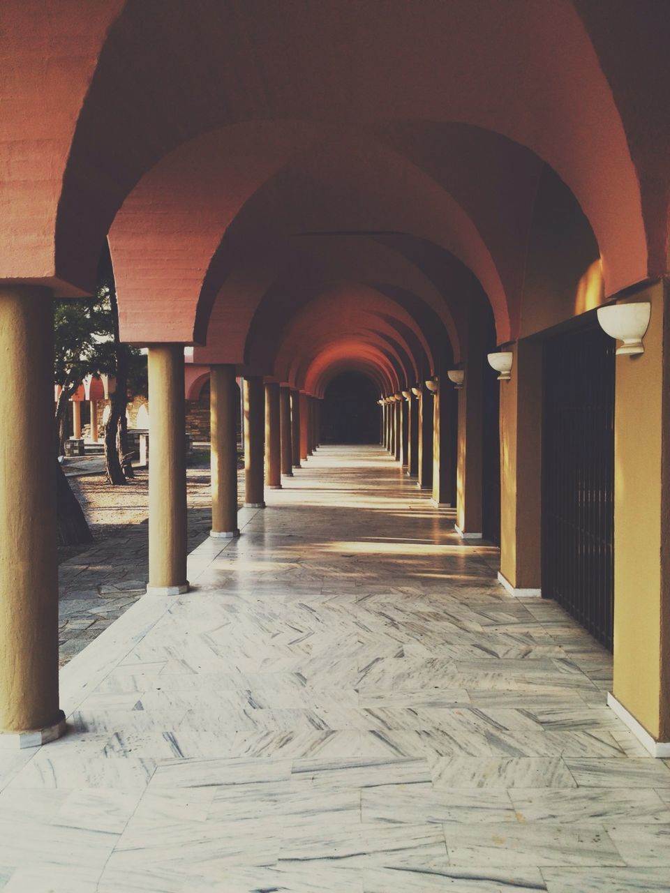 Long arched corridor with columns and marble flooring