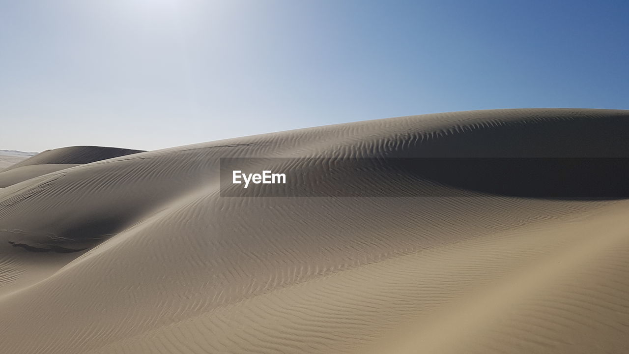 LOW ANGLE VIEW OF SAND DUNES AGAINST SKY