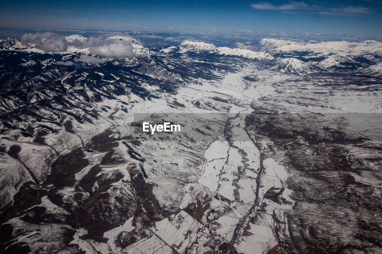 AERIAL VIEW OF DRAMATIC LANDSCAPE AND MOUNTAINS AGAINST SKY