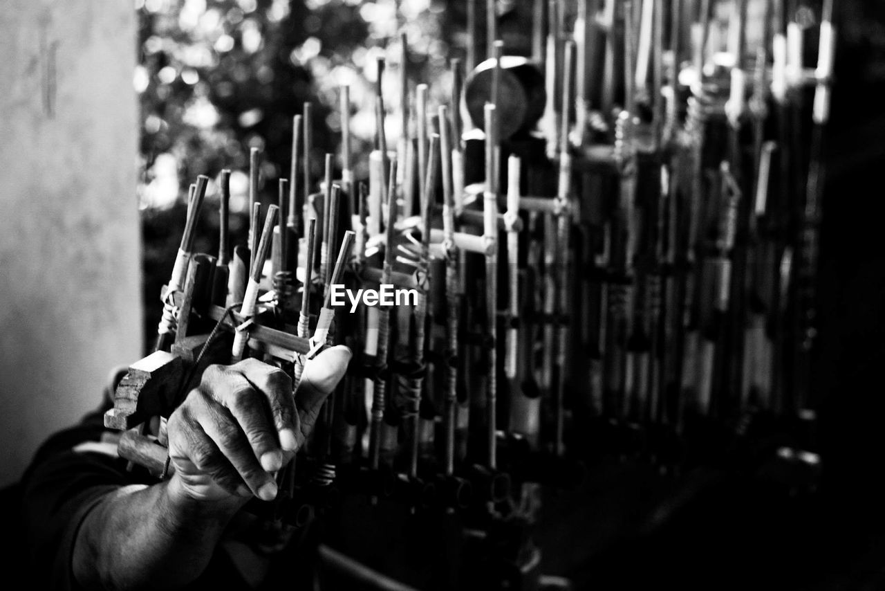 Cropped image of hand playing angklung