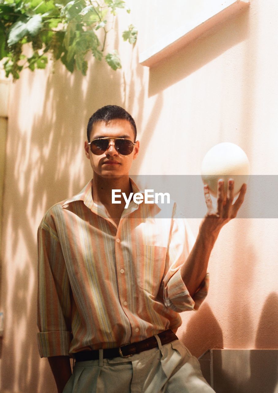 Portrait of young man wearing sunglasses standing outdoors