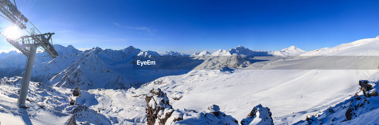 PANORAMIC VIEW OF SNOWCAPPED MOUNTAIN AGAINST BLUE SKY