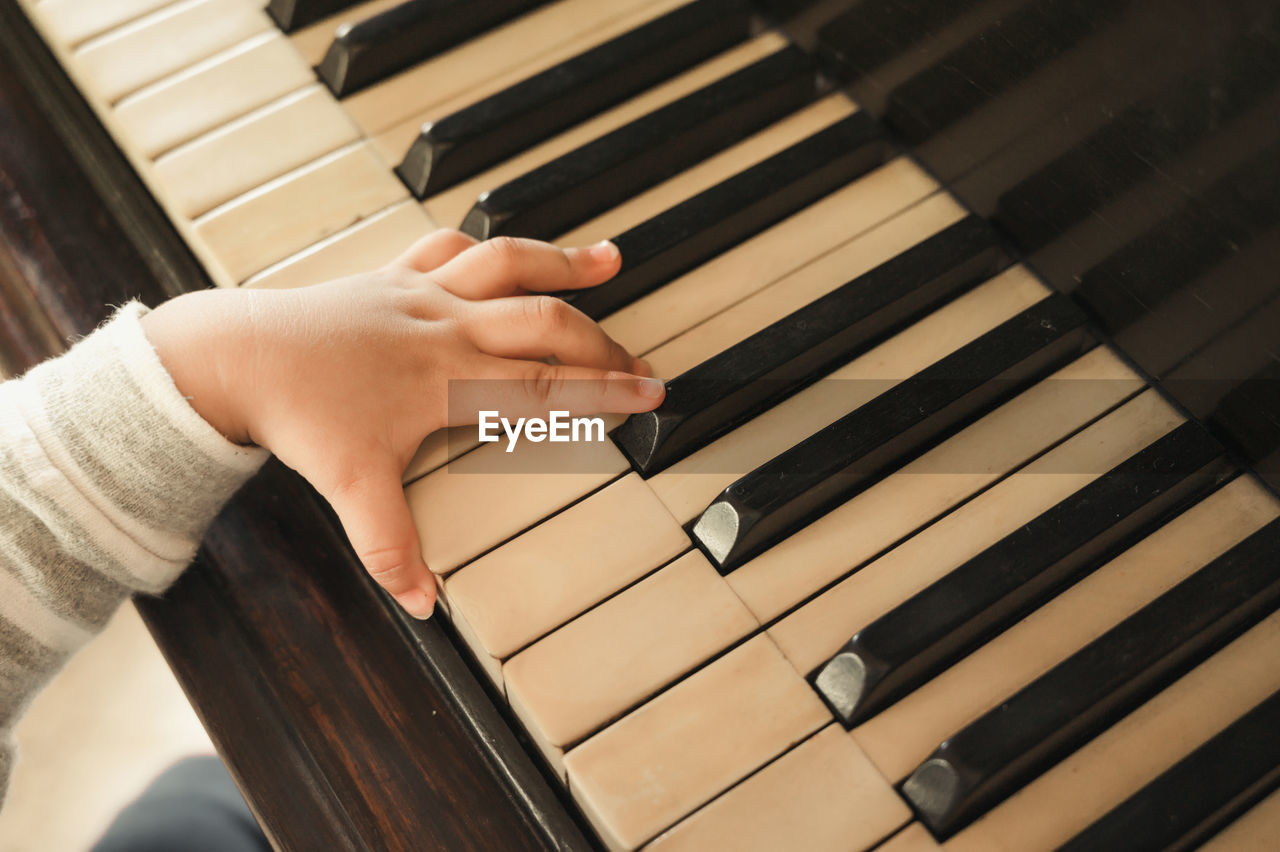 Cropped hand of baby playing piano