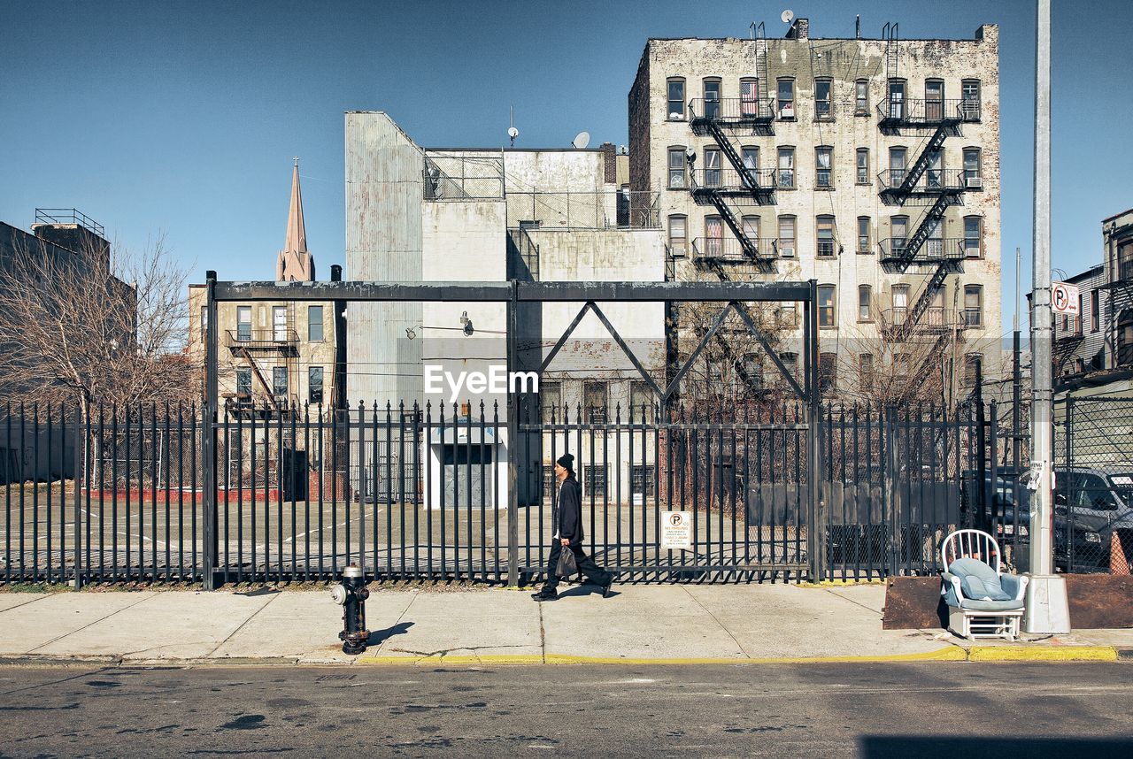 Side view of man walking against buildings
