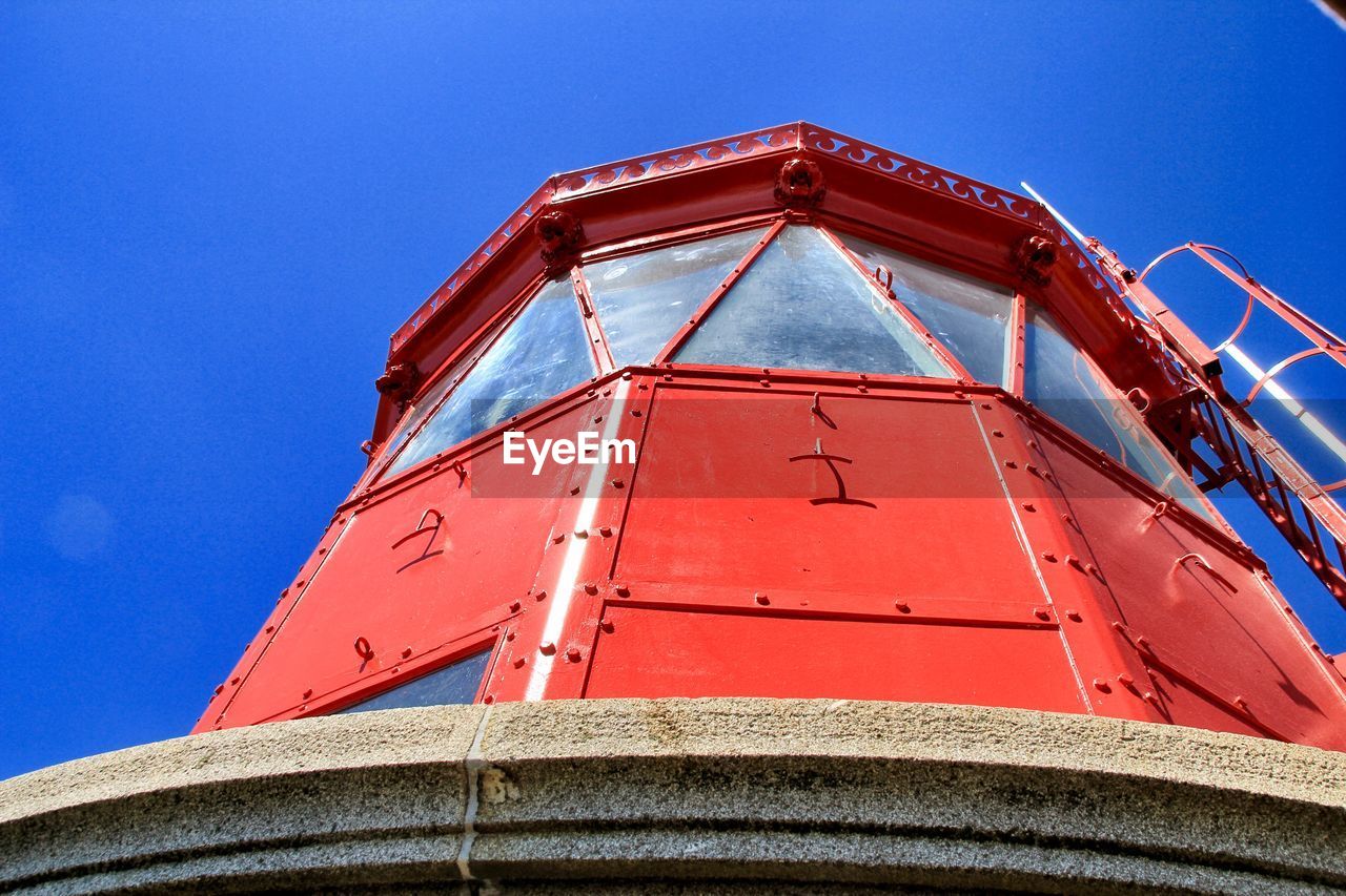 Low angle view of lighttower against clear blue sky
