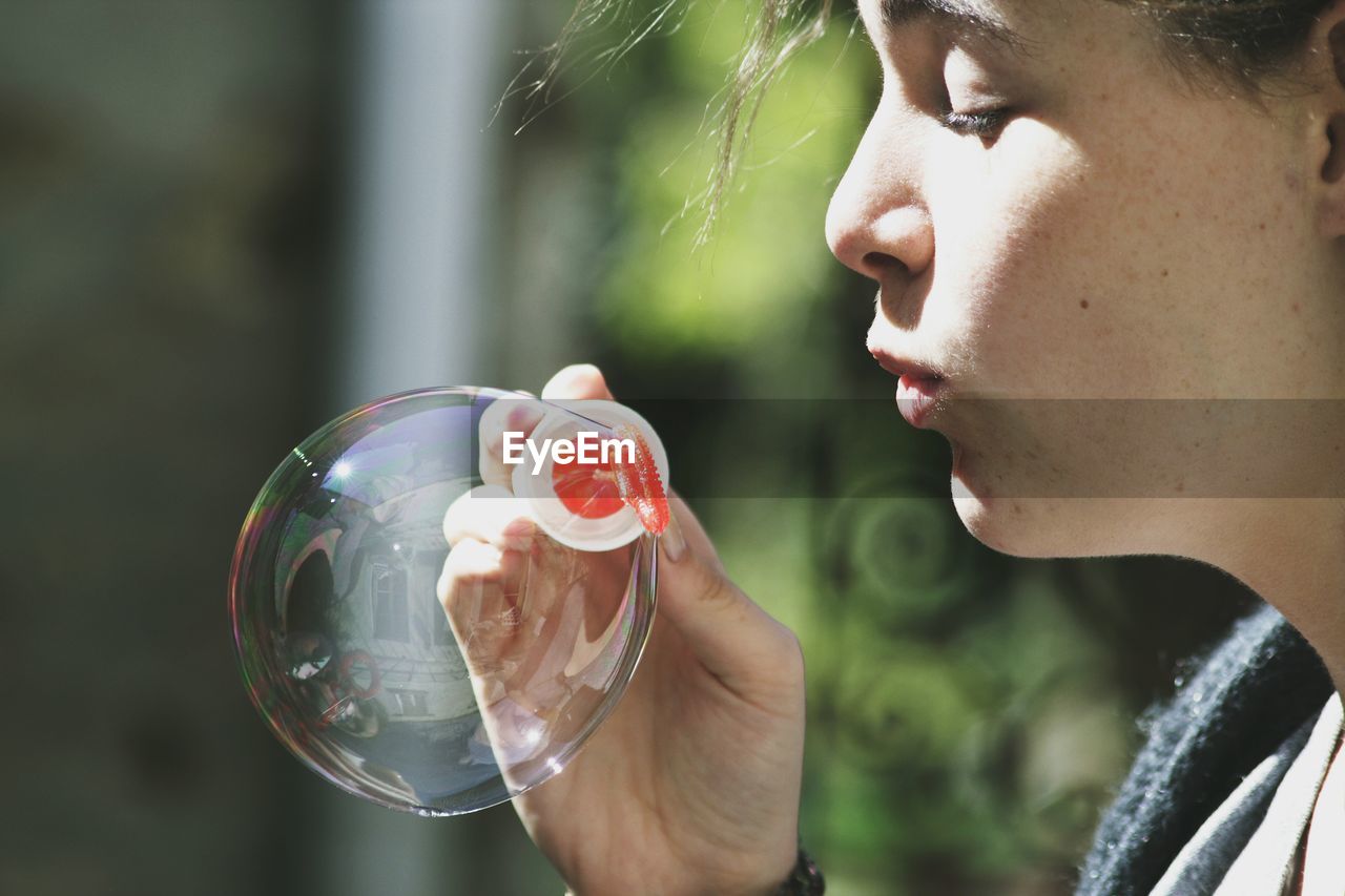 Close-up of woman blowing bubble