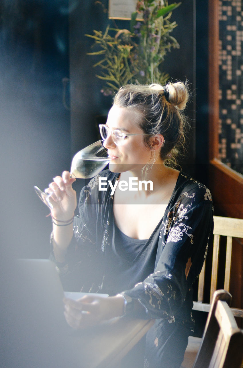 Young woman drinking alcohol in restaurant