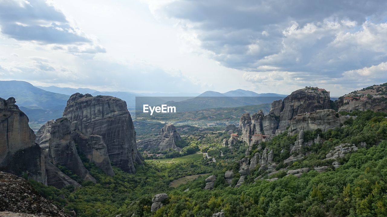 Scenic view of landscape against cloudy sky in meteora