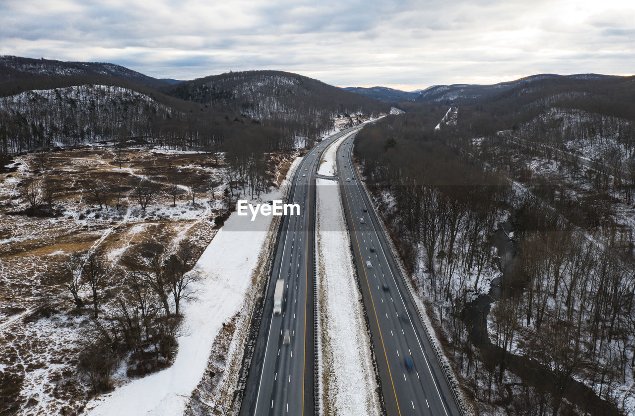 Aerial view of road passing through trees during winter