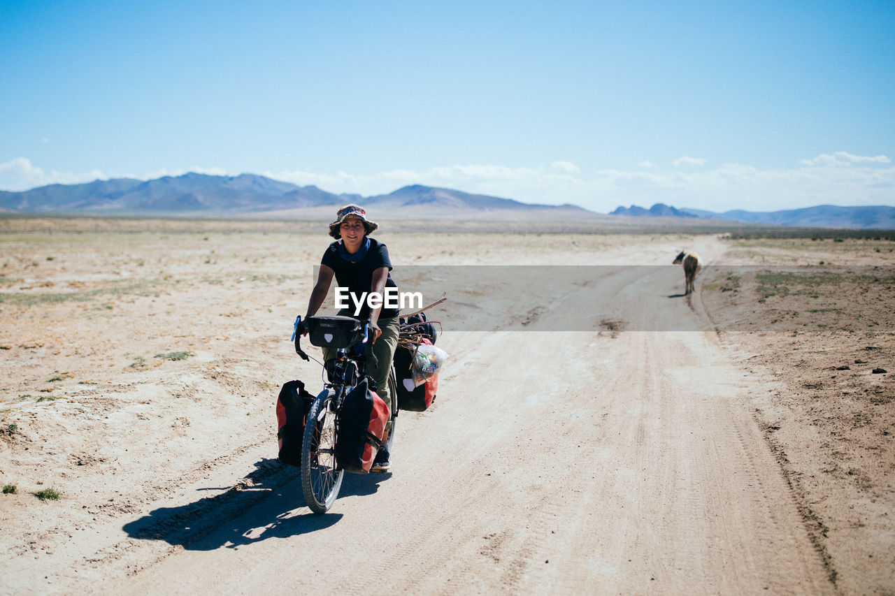 MEN RIDING MOTORCYCLE ON DESERT