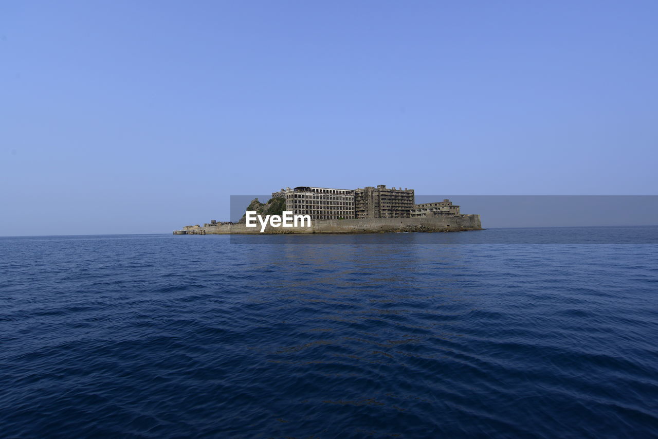 SCENIC VIEW OF SEA BY BUILDING AGAINST CLEAR SKY