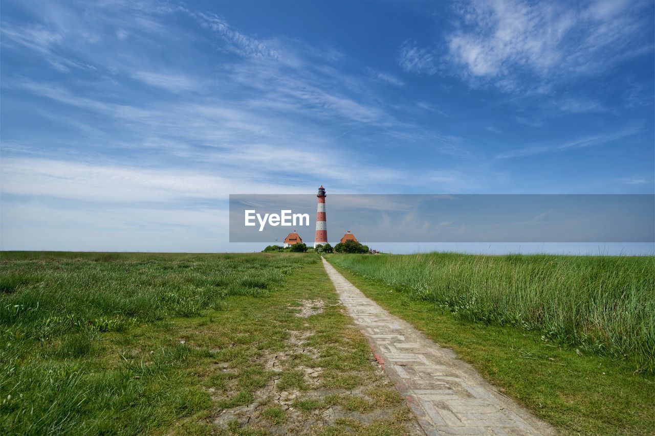 VIEW OF LIGHTHOUSE AMIDST FIELD AGAINST SKY