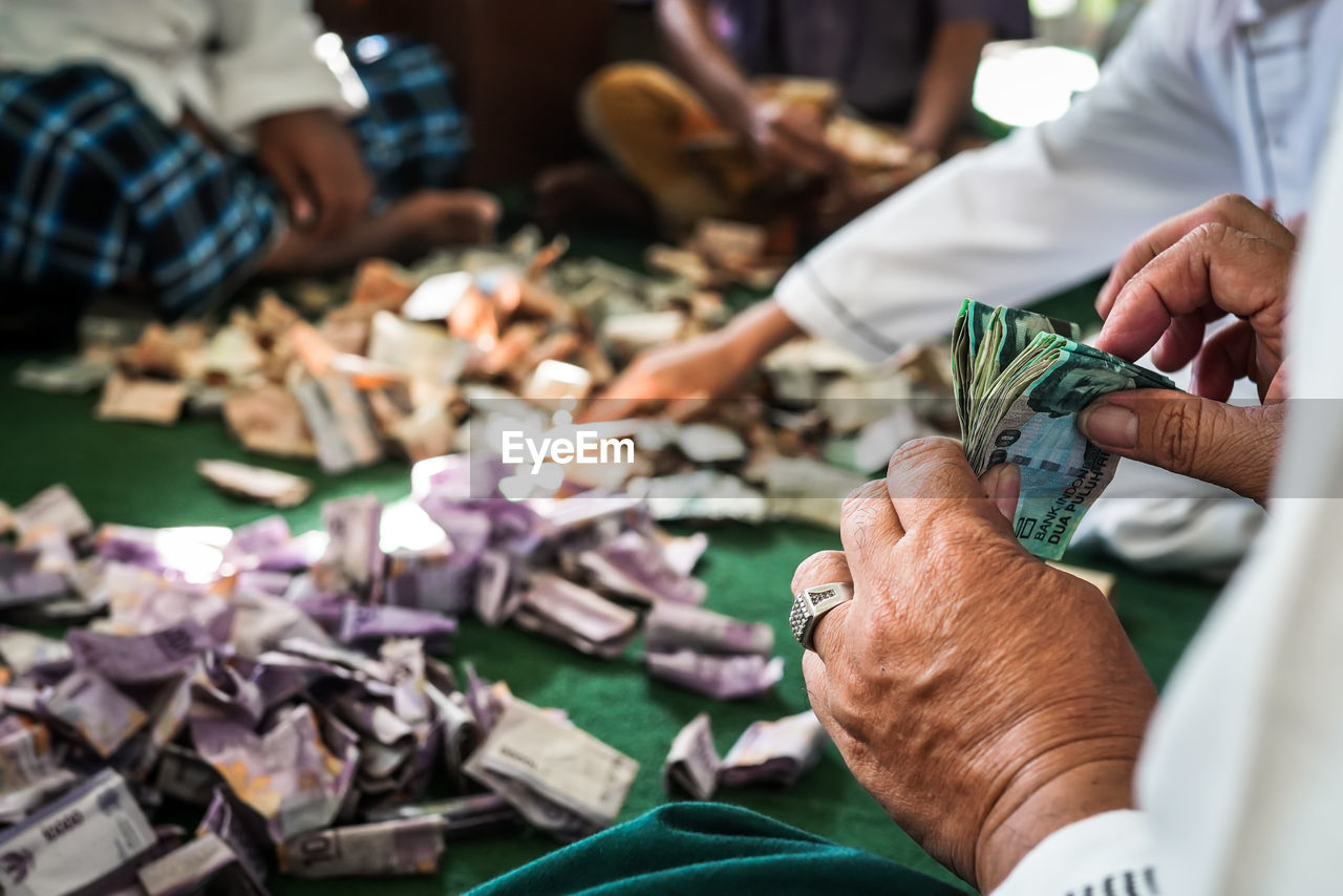 Midsection of people counting banknotes