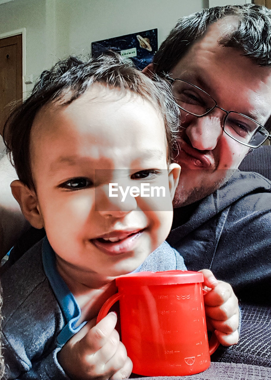 Close-up portrait of father and son at home