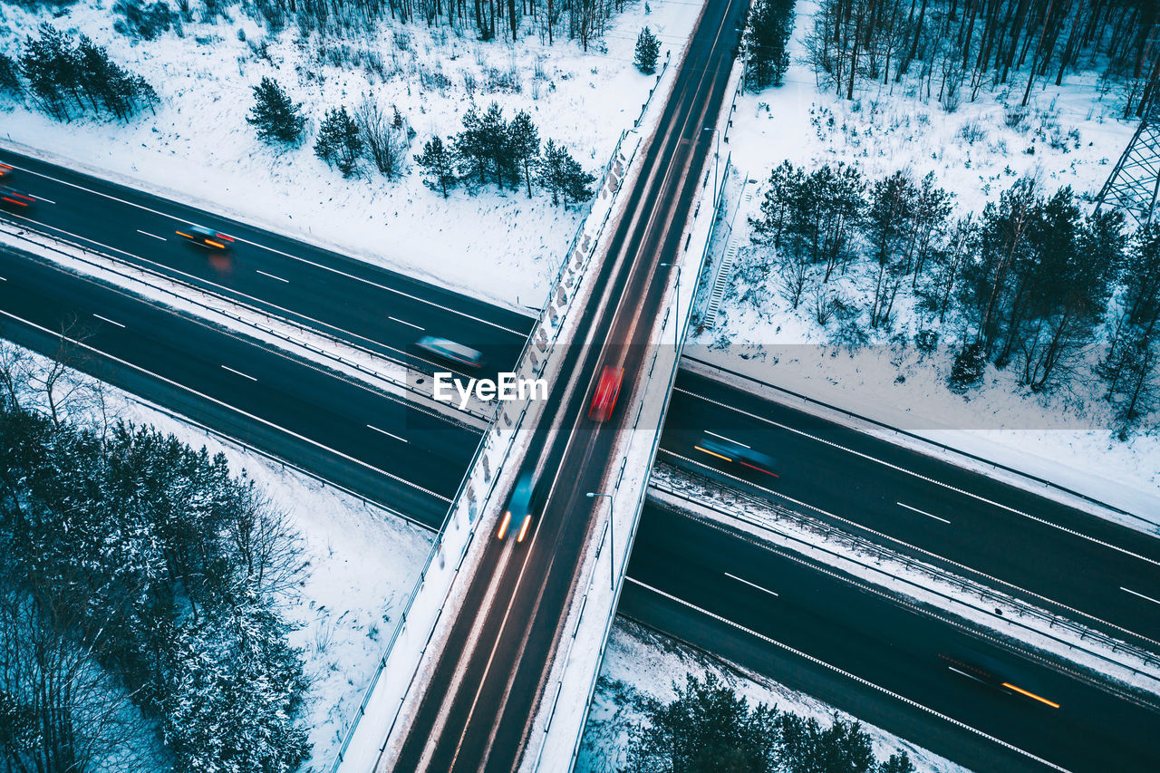 Aerial view of road amidst snow covered field