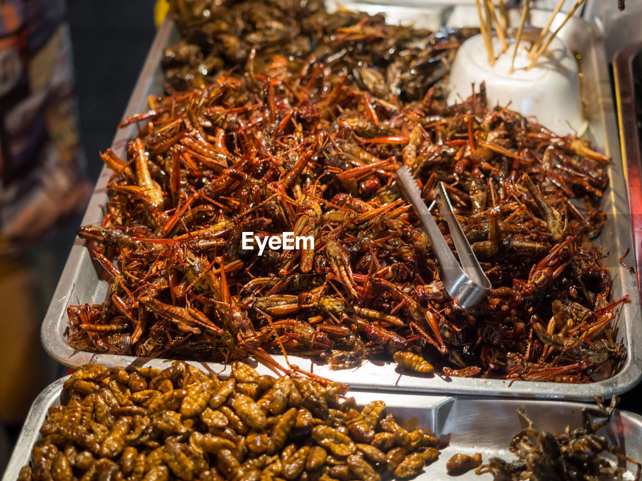 Close-up of fried crickets and maggots for sale in chinatown, bangkok, thailand