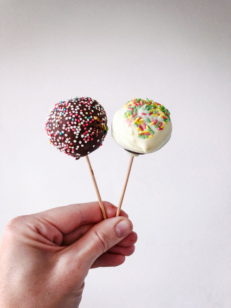 Two cake pops with multi-coloured sprinkles