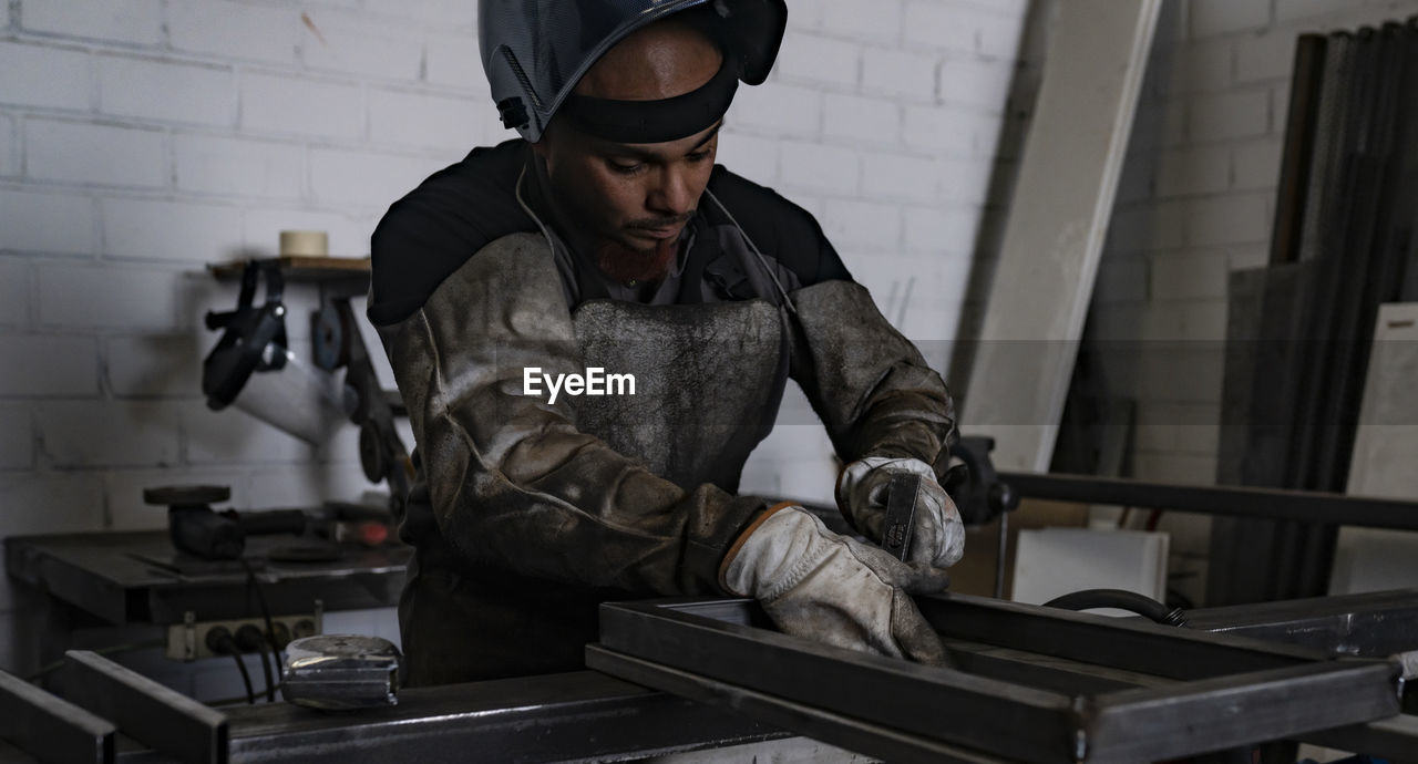 YOUNG MAN WORKING AT WORKSHOP