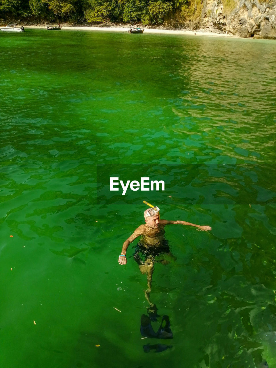 High angle view of man swimming in green water lake