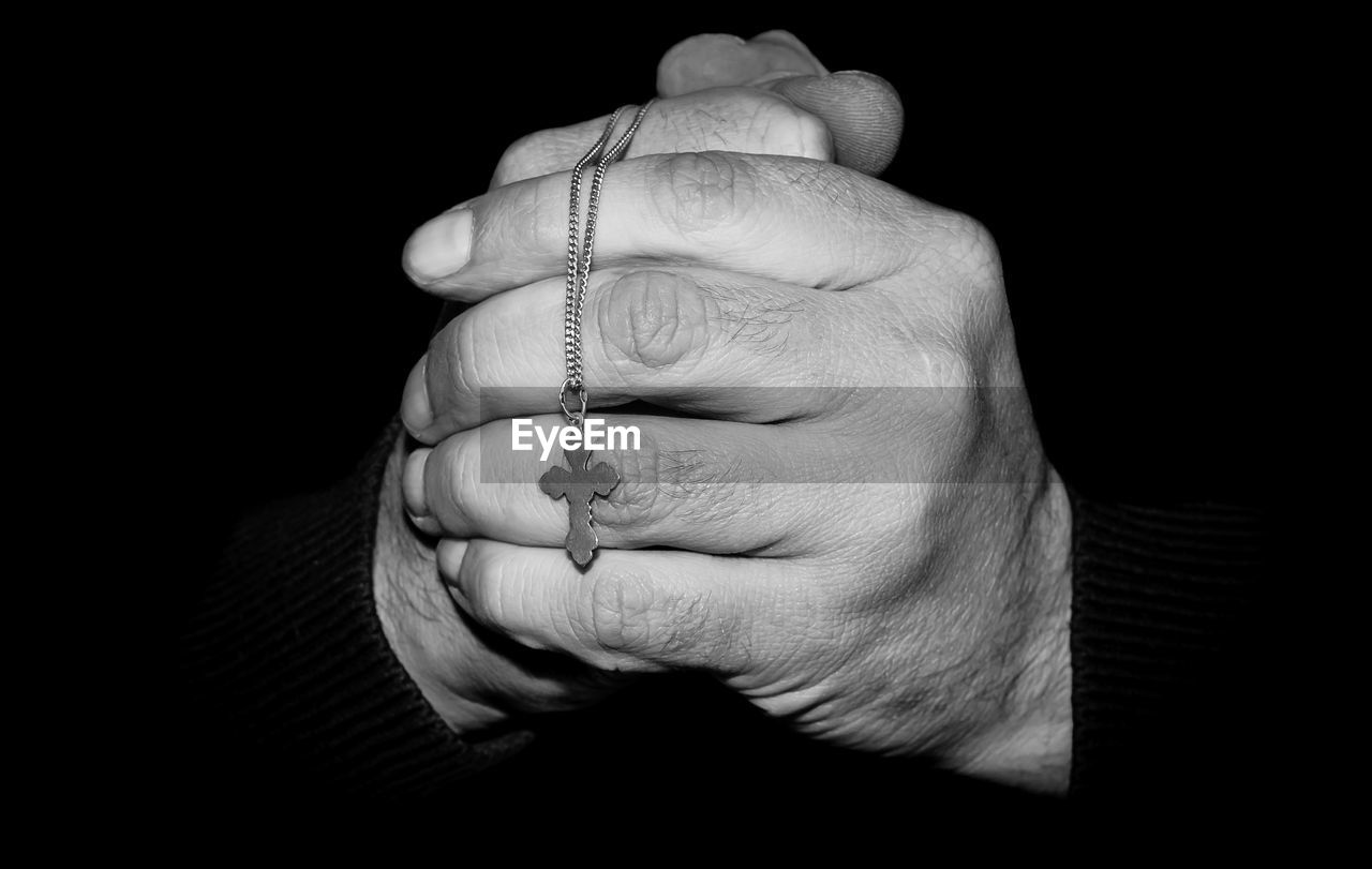 CLOSE-UP OF WOMAN HAND HOLDING BLACK BACKGROUND