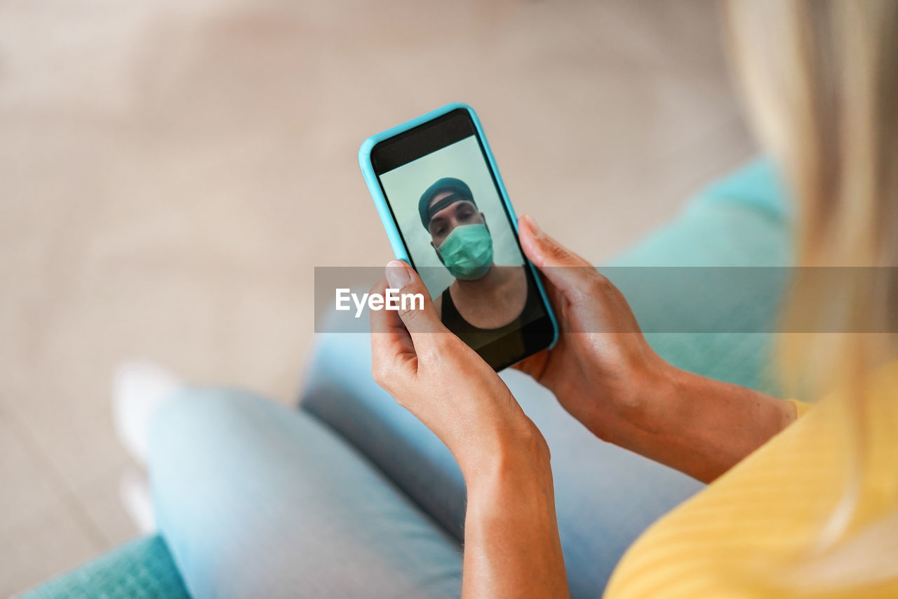 Midsection of woman video calling over smart phone