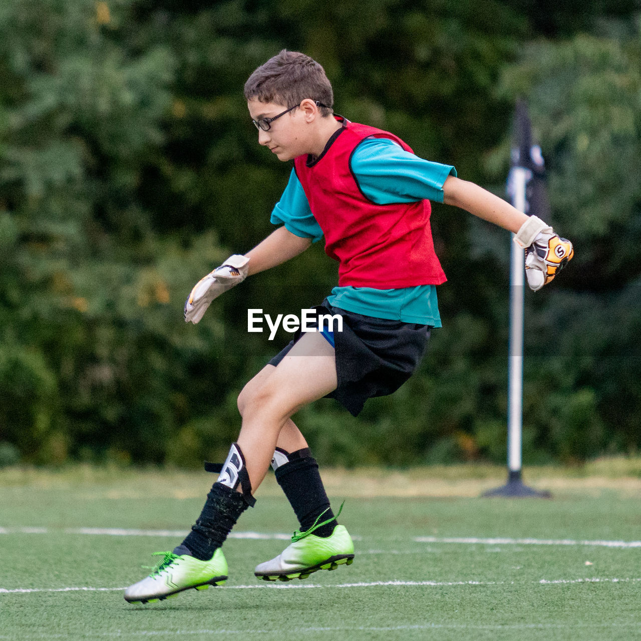 Full length of boy playing soccer on grass