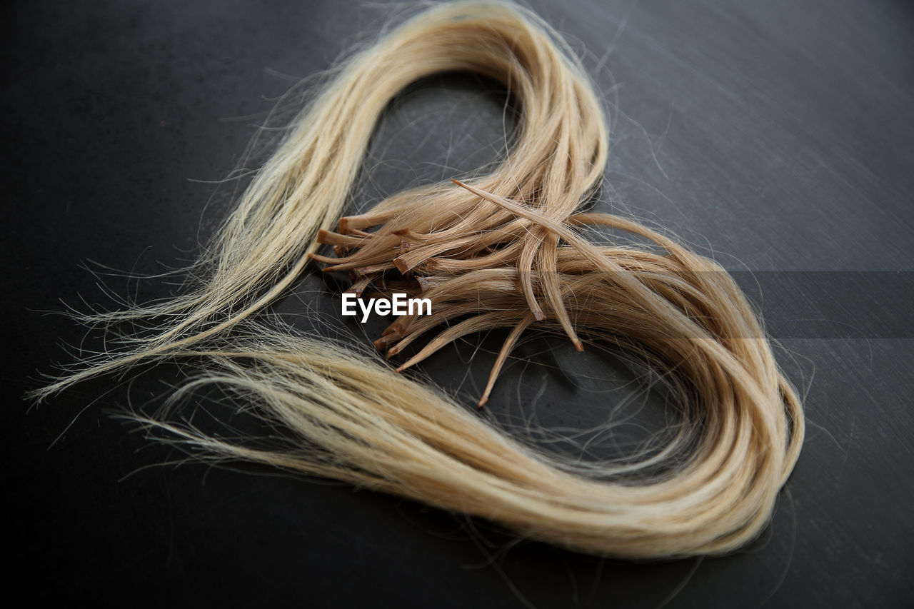 Photo of ready-made keratin-encapsulated strands of light hair for extension.