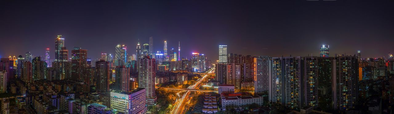 PANORAMIC VIEW OF ILLUMINATED CITYSCAPE AGAINST SKY
