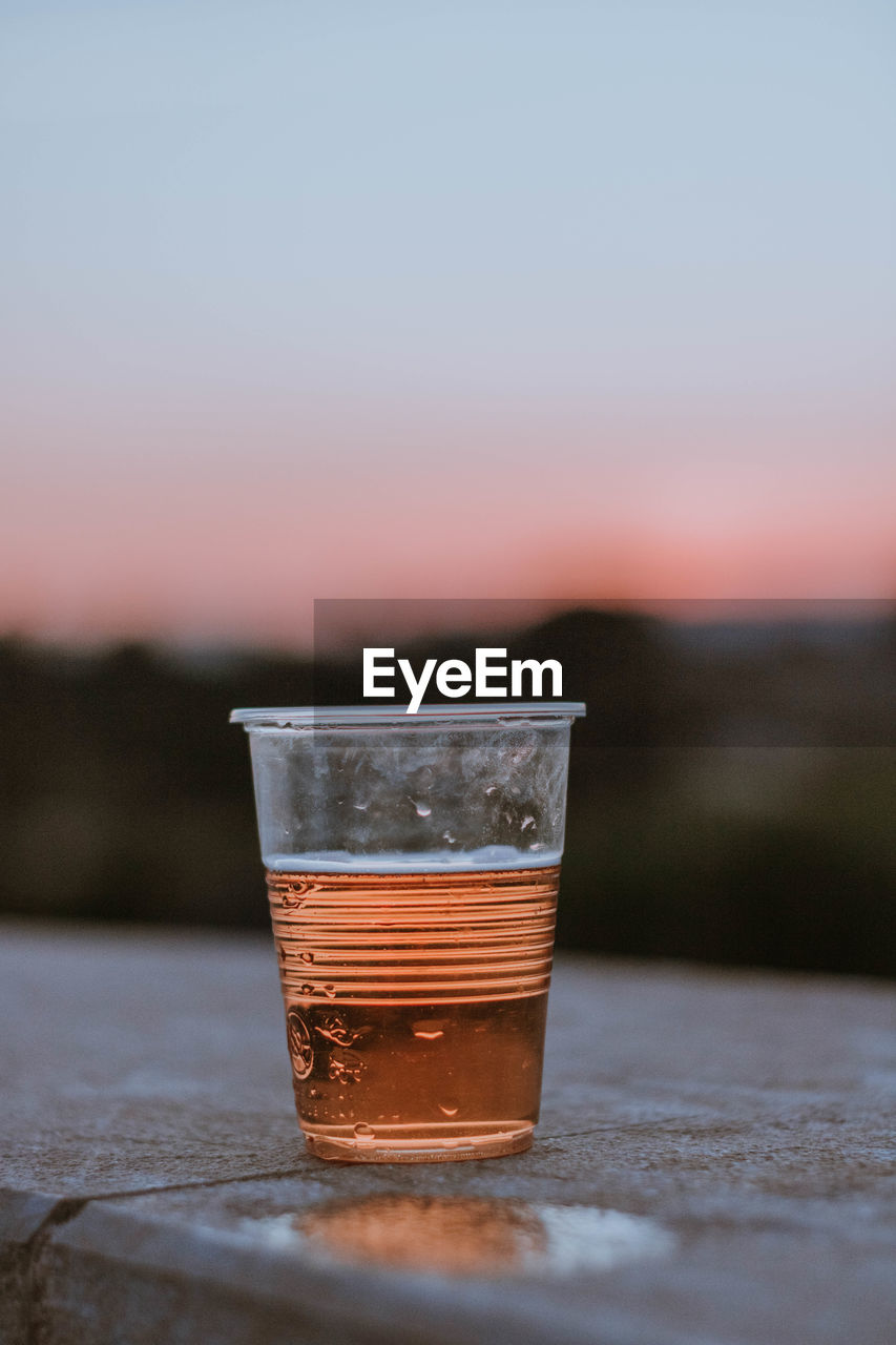 drink, refreshment, food and drink, drinking glass, glass, morning, household equipment, alcohol, reflection, no people, macro photography, sky, close-up, water, table, blue, nature, yellow, cold temperature, focus on foreground, red, outdoors, alcoholic beverage, freshness, still life, wood, copy space, selective focus