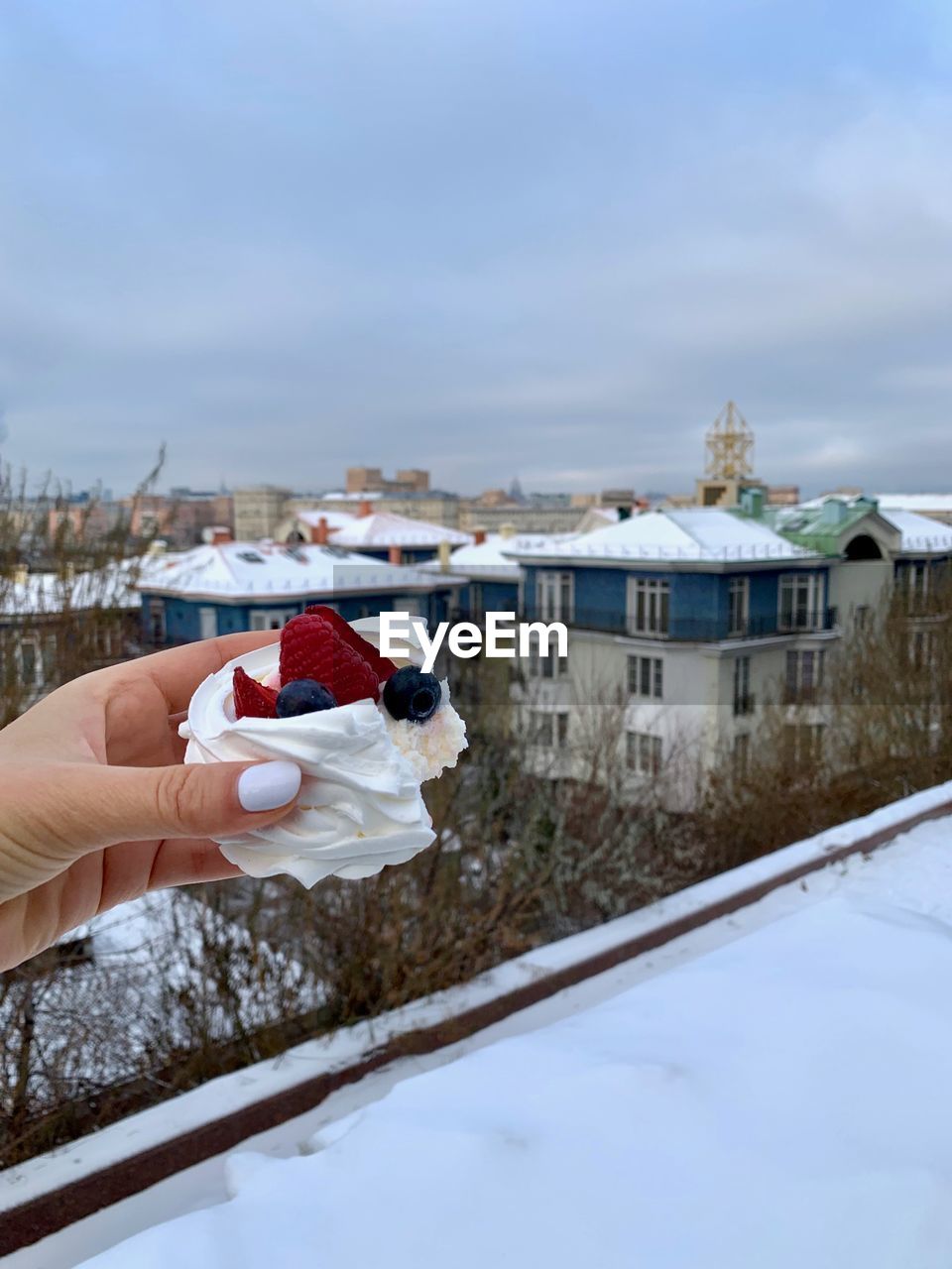 Dessert pavlova in a hand with moscow view
