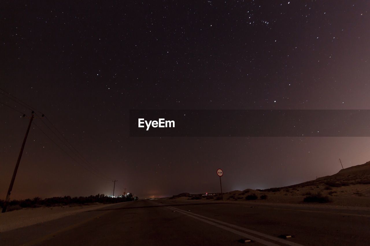 Road against clear sky at night