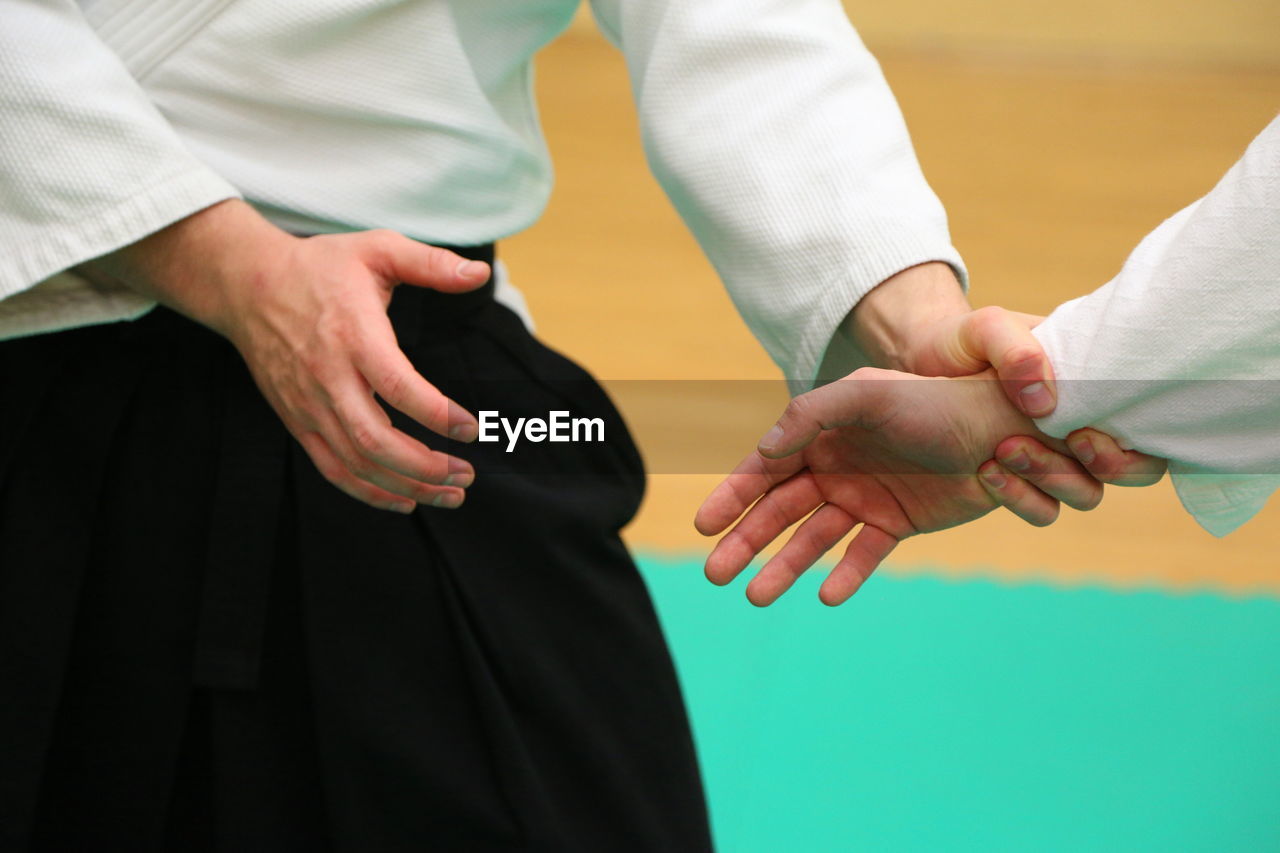 Man with trainer practicing aikido