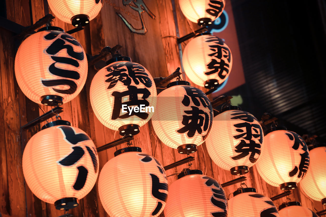 Low angle view of text on illuminated lanterns at night