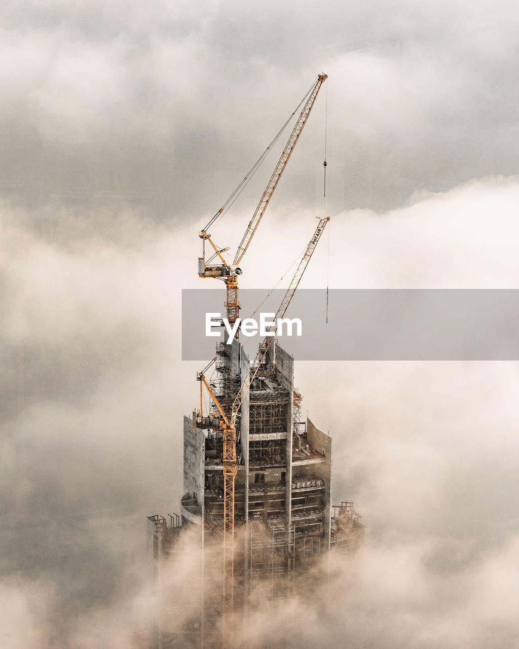 cloud - sky, sky, industry, construction industry, built structure, architecture, crane - construction machinery, building exterior, machinery, construction site, no people, nature, development, day, low angle view, incomplete, outdoors, smoke - physical structure, tall - high