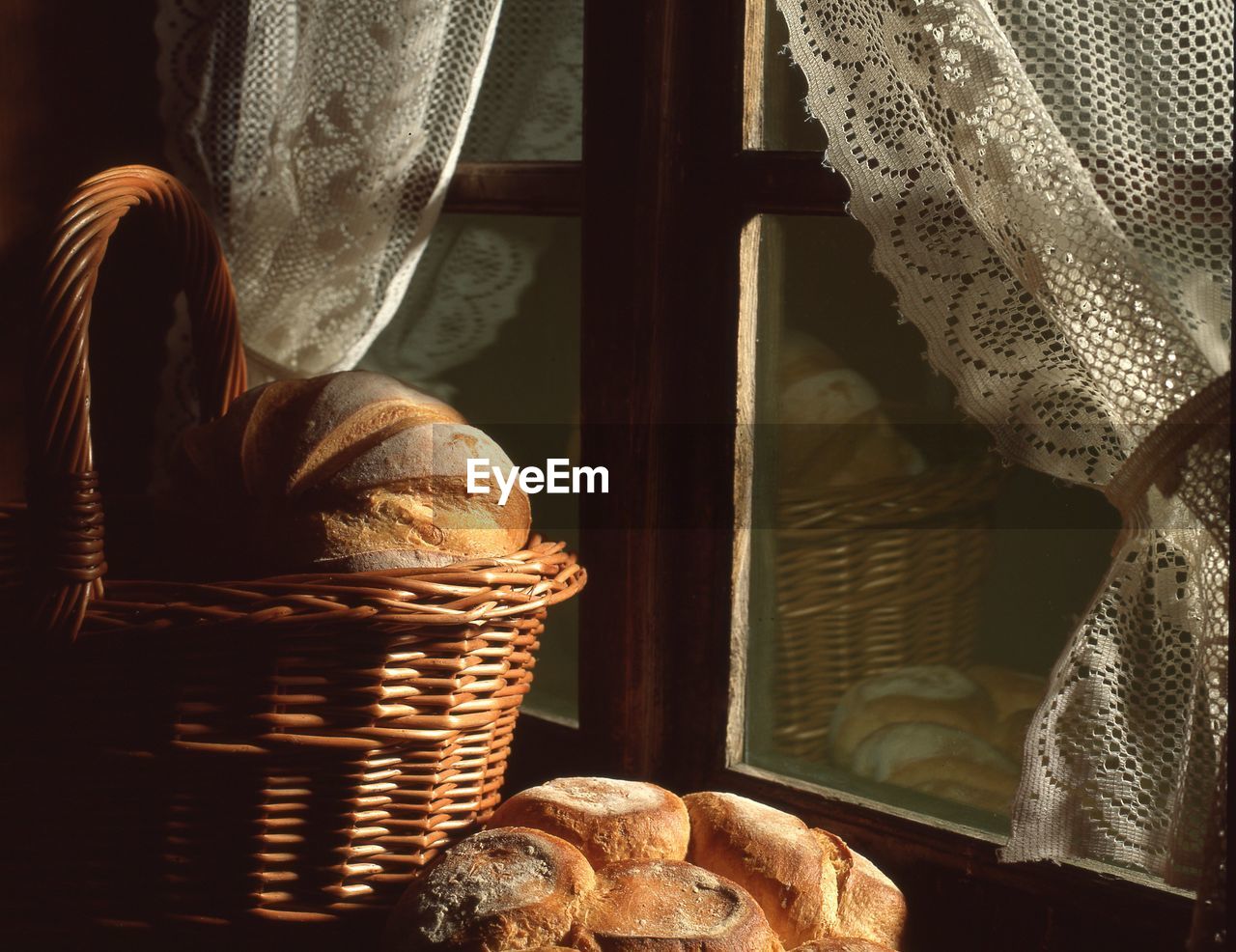 Brown breads in basket by closed window