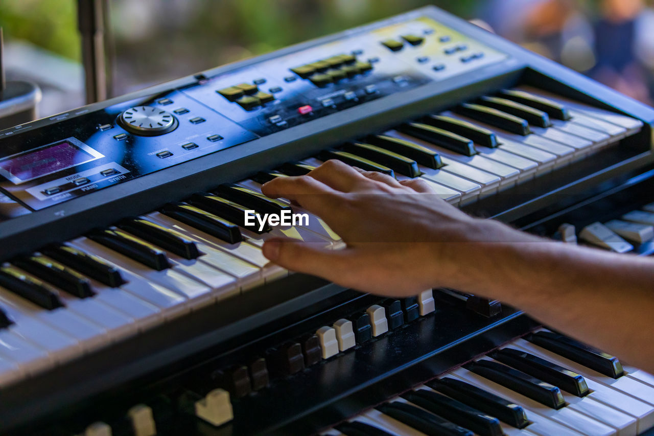 Close-up of hand playing piano