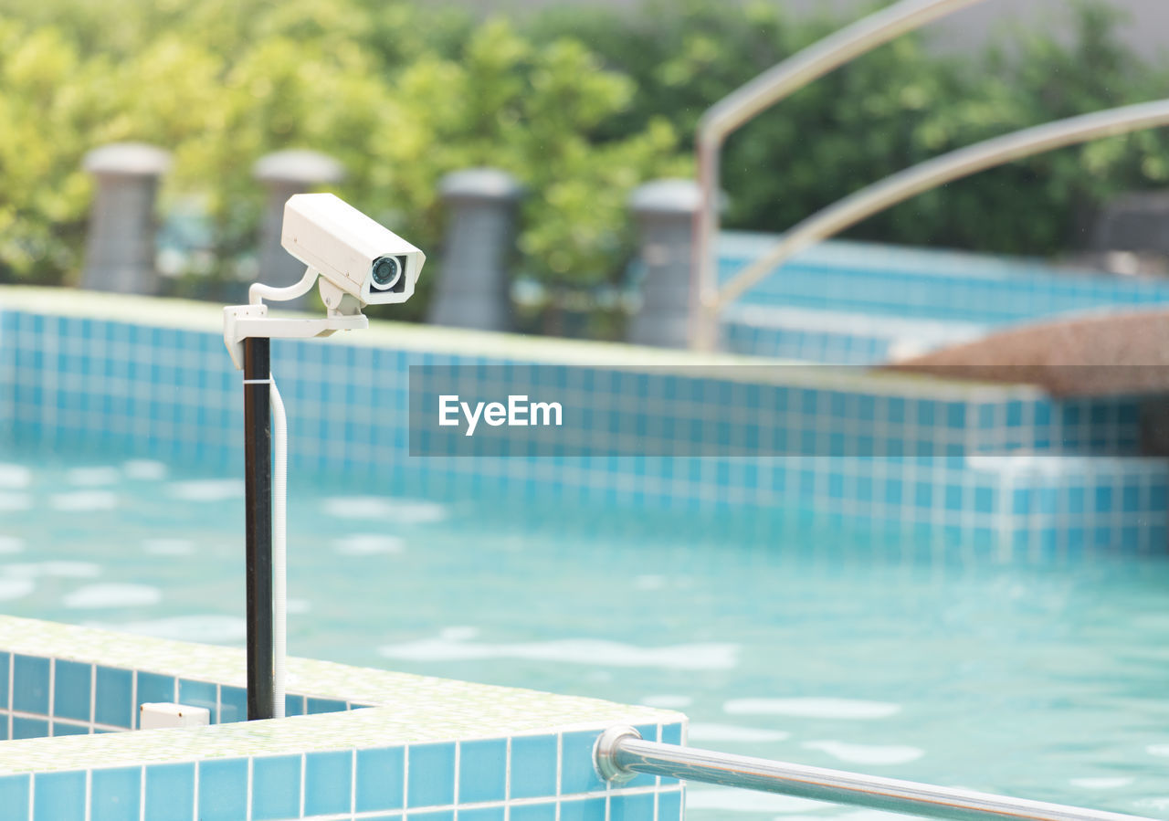 Close-up of security camera by swimming pool