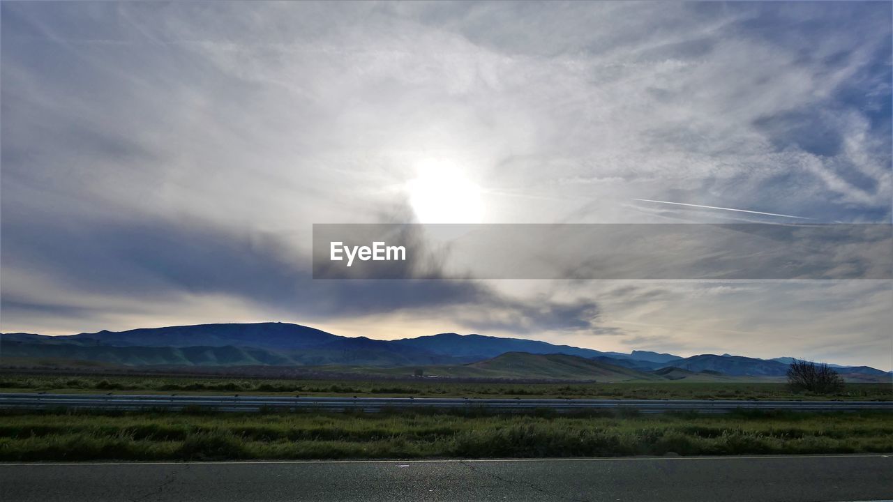 SCENIC VIEW OF ROAD BY MOUNTAINS AGAINST SKY