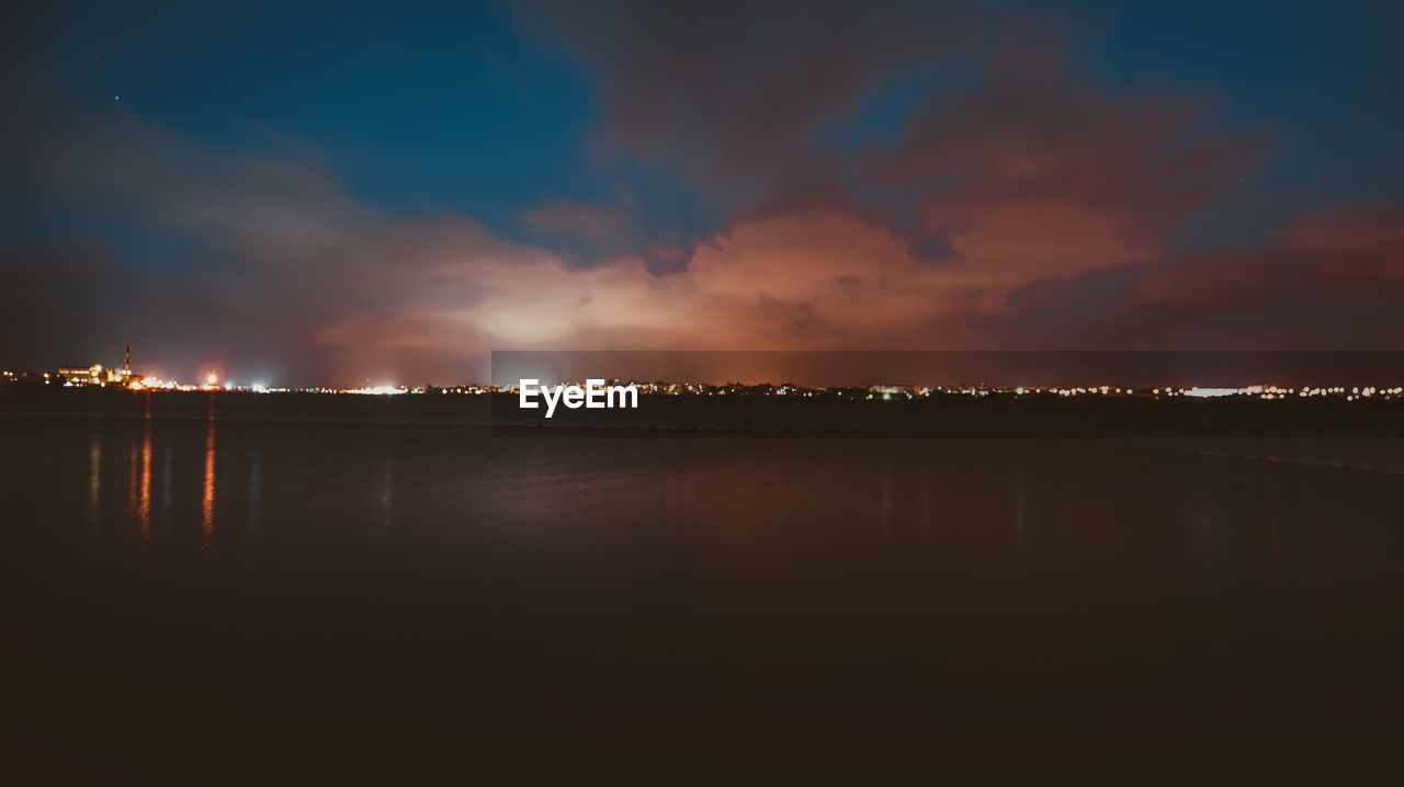 Illuminated cityscape against sky at night