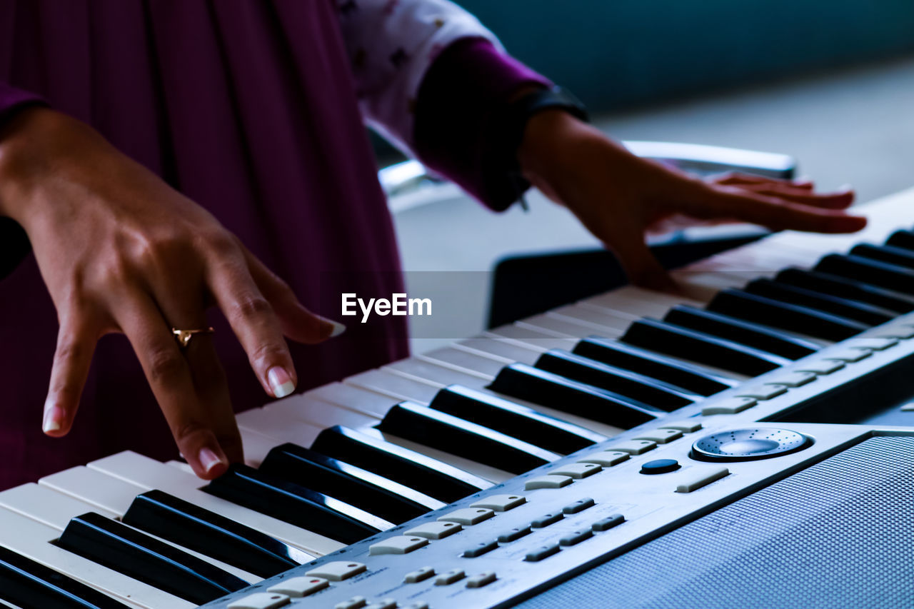Cropped image of woman playing piano
