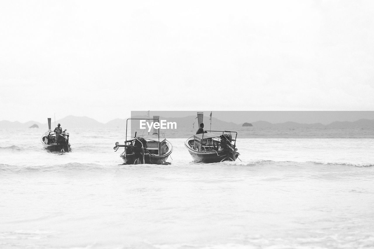 Motor boats on sea against sky