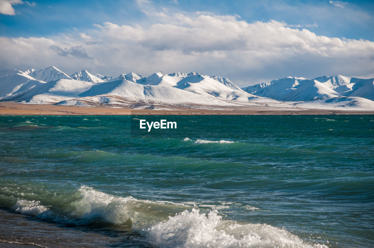 The heavenly lake namtso in tibet with snow covered nyenchen tanglha mountains in the distance