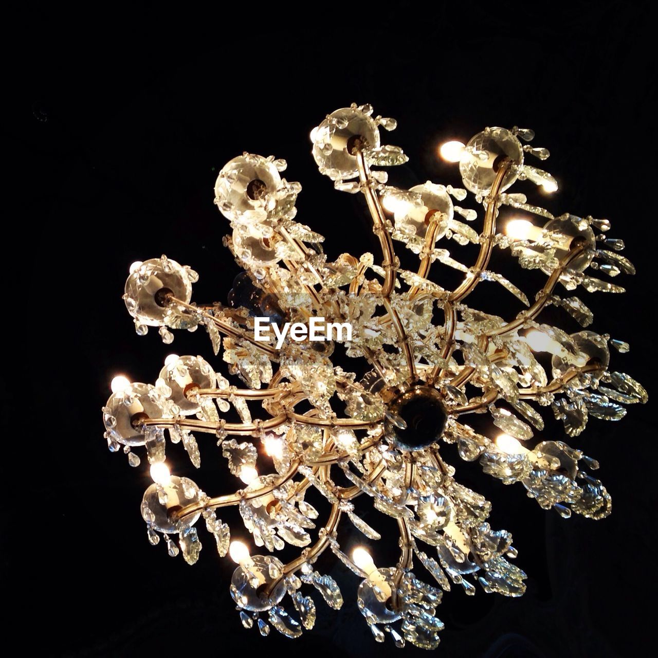 Low angle view of chandelier over black background