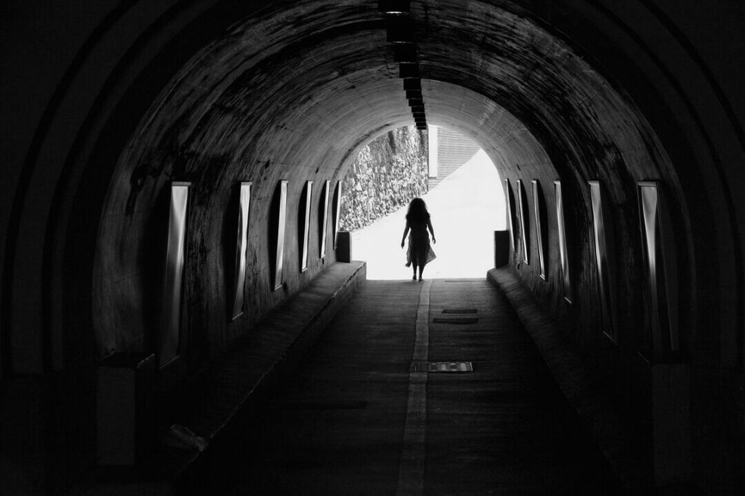 WOMAN WALKING IN TUNNEL