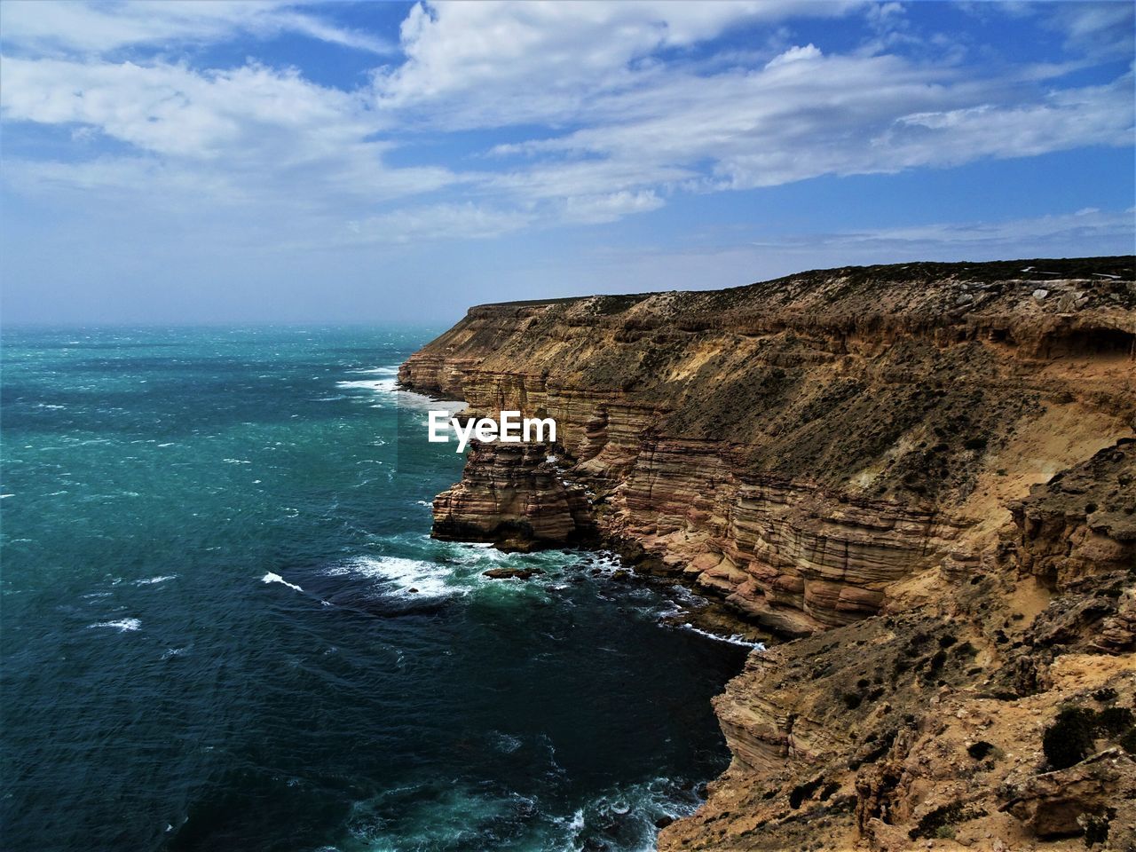 Rock formations by sea against sky